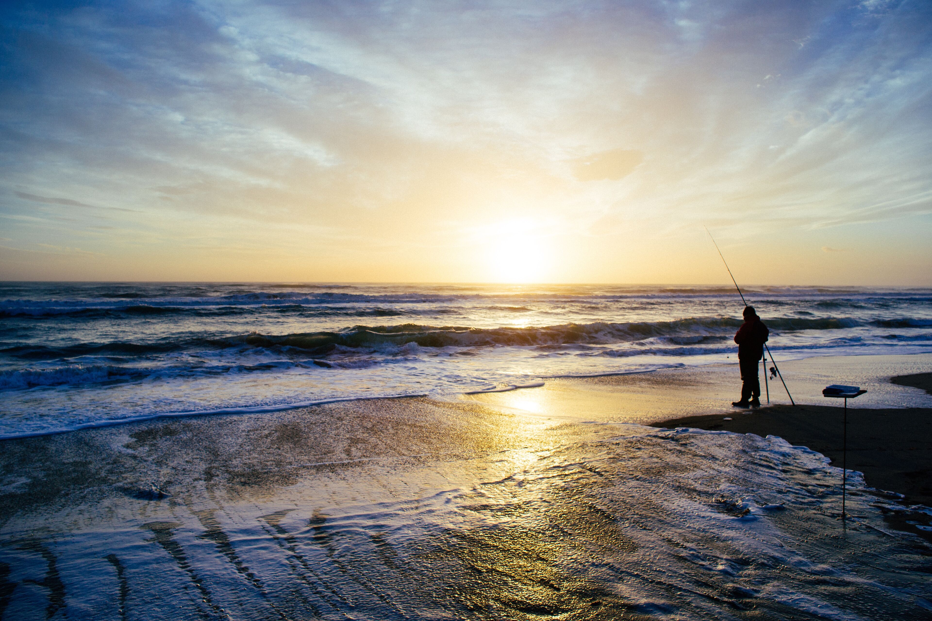 Silhouette of a Fisherman on the beach at sunset, Pescia Romana, Lazio, Italy