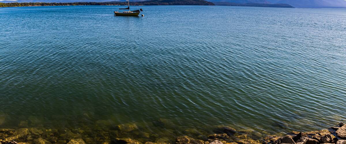 Yellow Sailboat on Lake Pend d' Oreille With Mountains From Pend d’ Oreille Bay Trail , Sandpoint, Idaho, USA