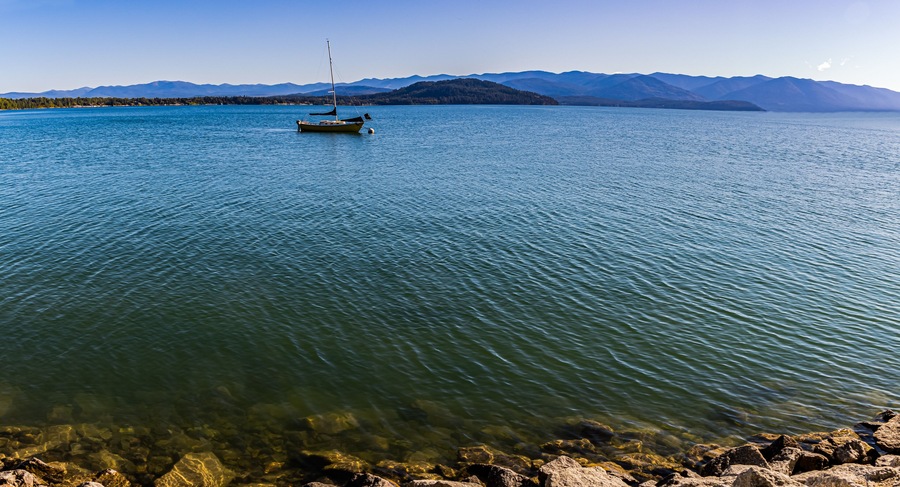 Yellow Sailboat on Lake Pend d' Oreille With Mountains From Pend d’ Oreille Bay Trail , Sandpoint, Idaho, USA