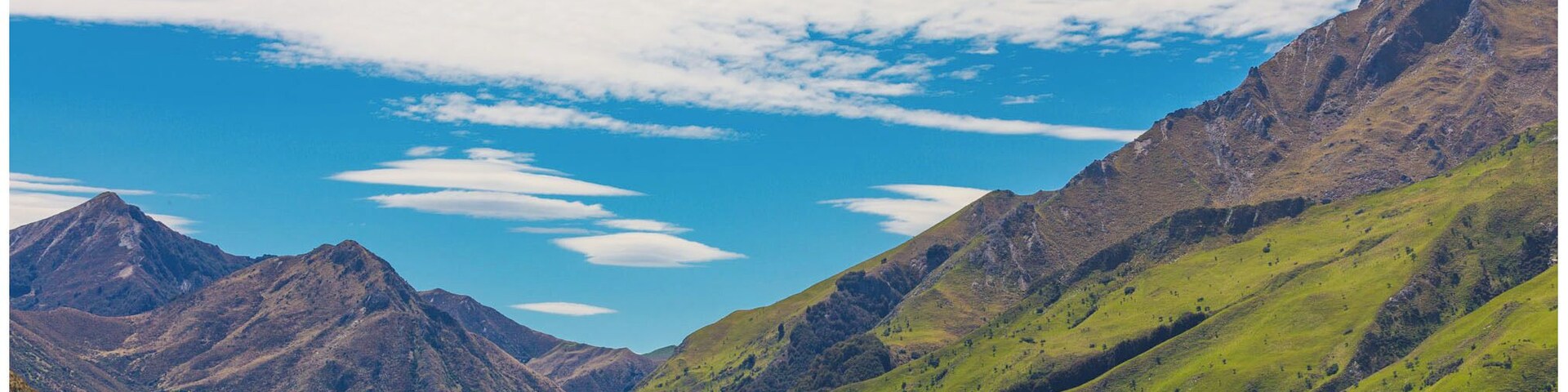 Un paisaje montañoso con un lago y cielo despejado.
