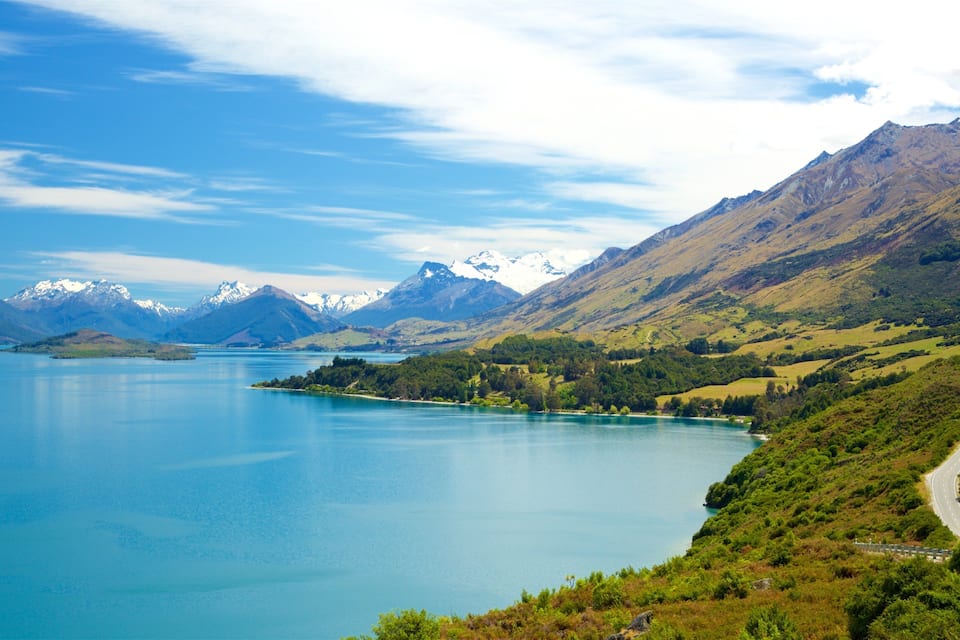 A lake surrounded by mountains with a winding road.