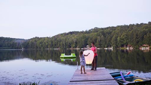 Two girls standing on jetty, releasing sky lantern