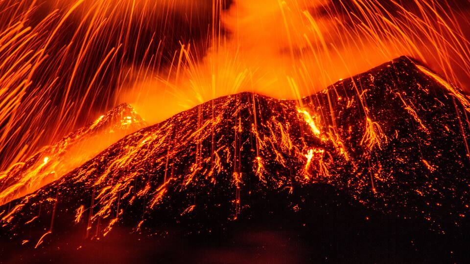 A volcano with flowing lava and bright orange glow.