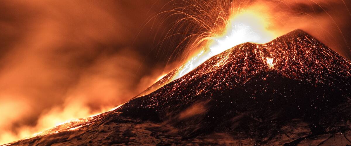 A volcano erupting with glowing lava and bright sparks.