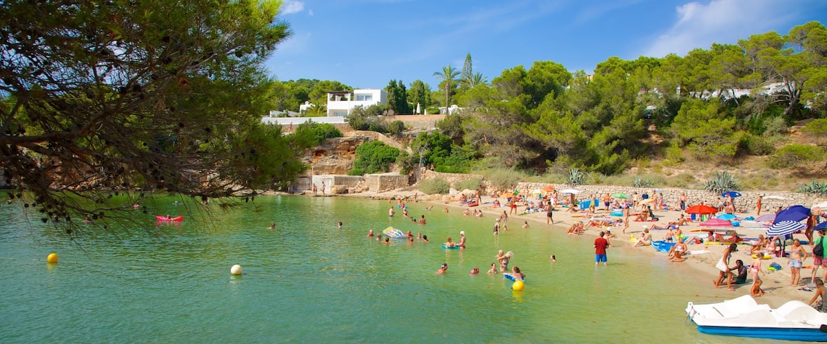 A crowded beach with people swimming and sunbathing.