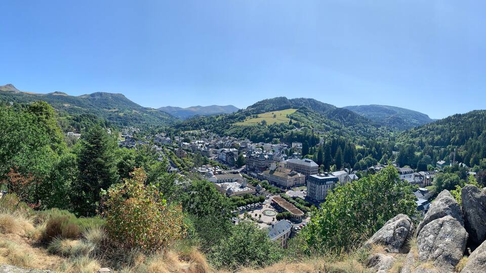 A town nestled in a valley with mountains in the background.