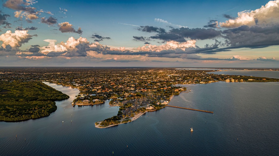 An aerial view of a coastal city with a bay, a peninsula, and a bridge connecting them.