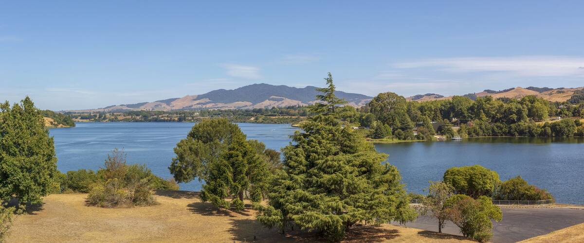 A lake surrounded by trees and hills.