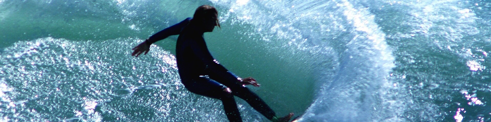 Un surfista montando una ola grande en el océano.