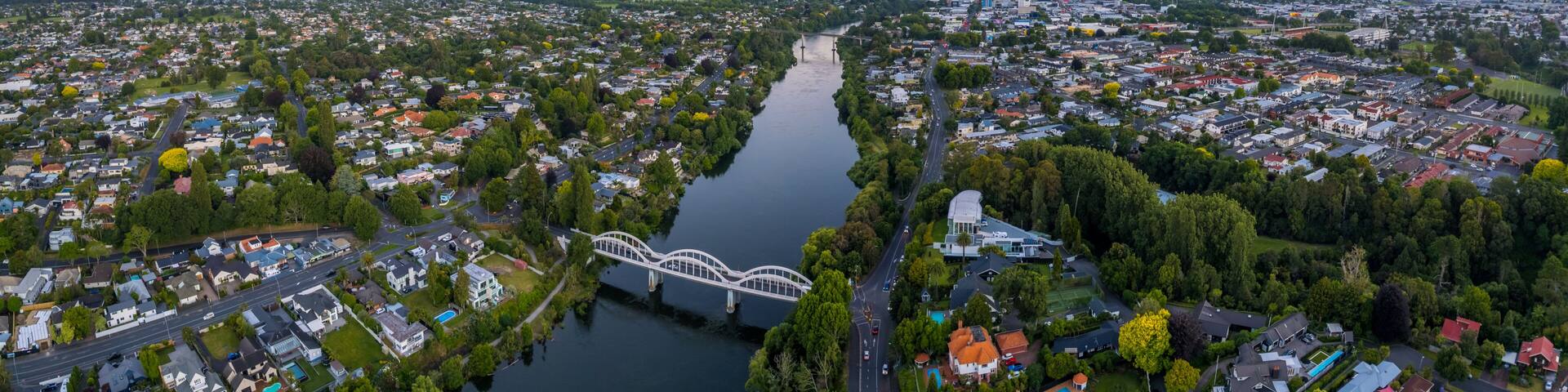 A river flowing through a densely populated urban area with a prominent bridge.