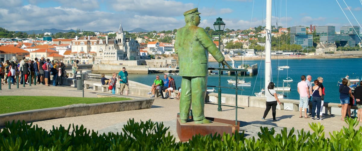 A green statue of a man in uniform, a harbor with boats, and a cityscape with buildings in the background.