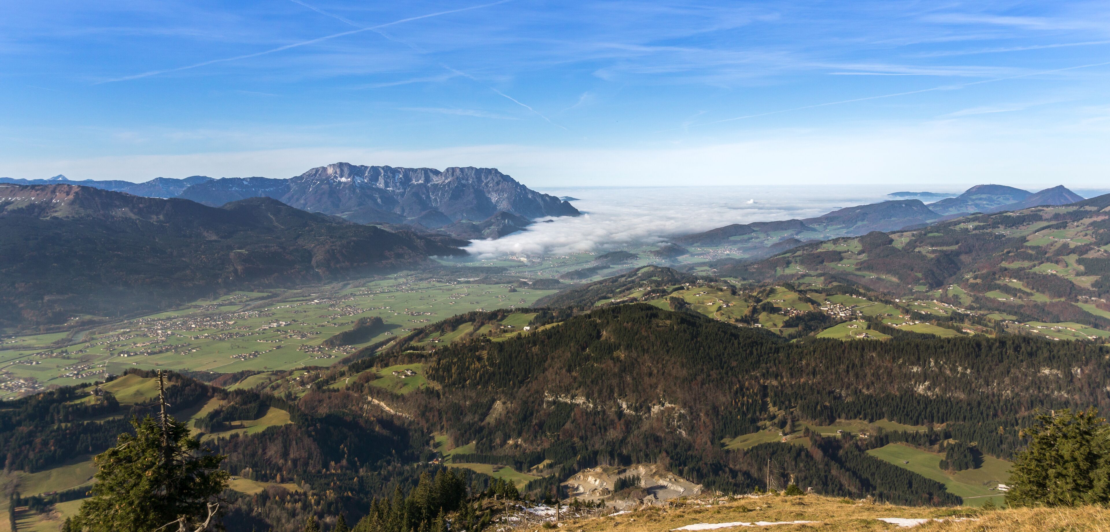 A mountainous landscape with a valley, a village, and a prominent mountain peak.