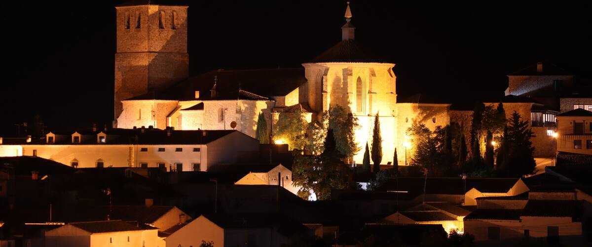 A historic building with a prominent tower and a large dome, surrounded by trees and other buildings.