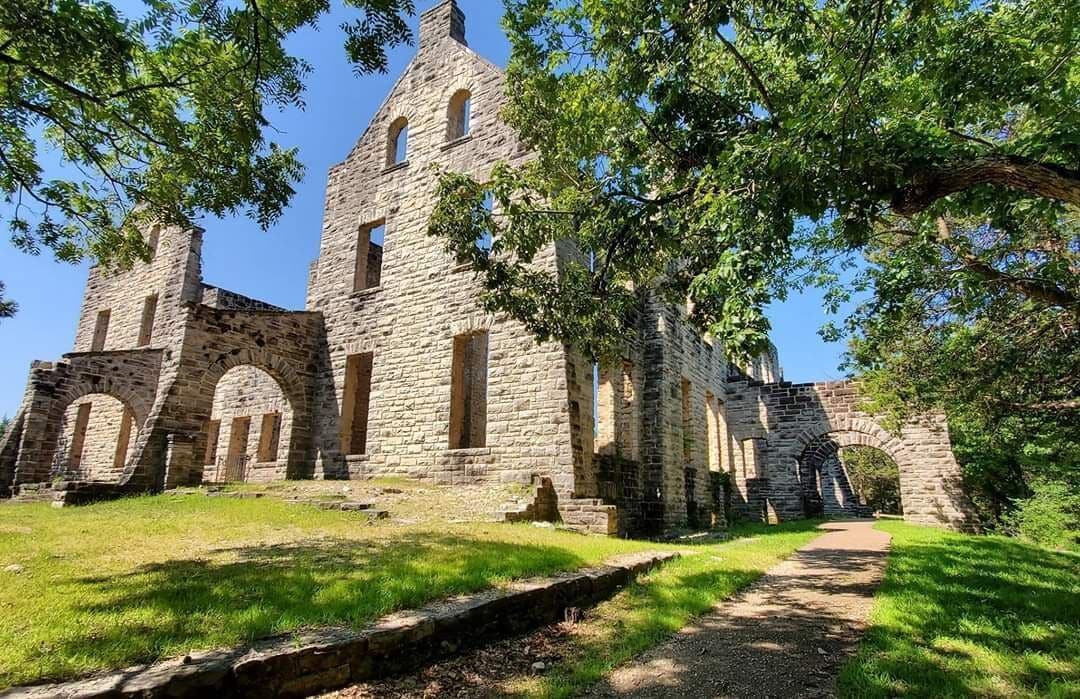 A historic stone building with arched windows and a prominent tower.