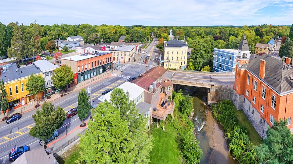 A town with a river, historic buildings, and a bridge.