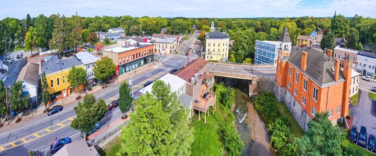 A town with a river, historic buildings, and a bridge.