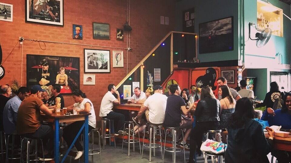 More hipsters drinking in a cool craft beer spot.