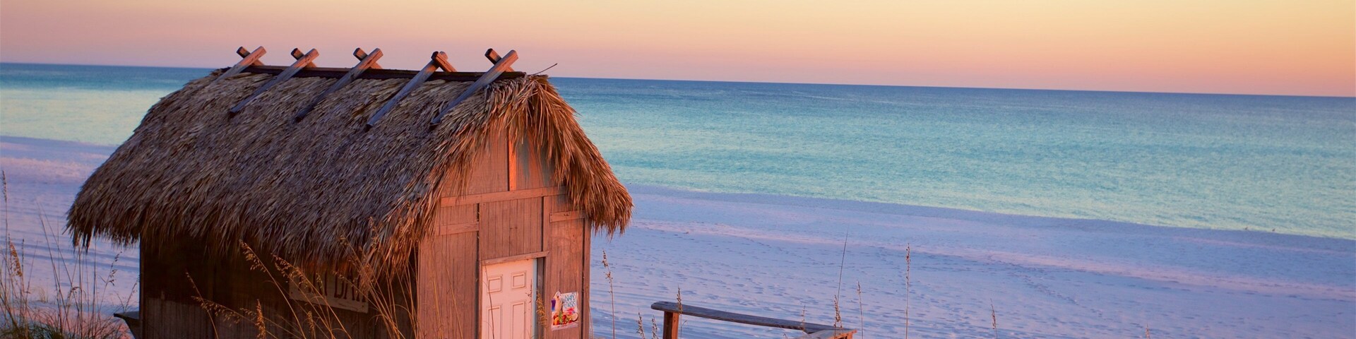 Florida Panhandle featuring a bay or harbor, a sunset and a beach