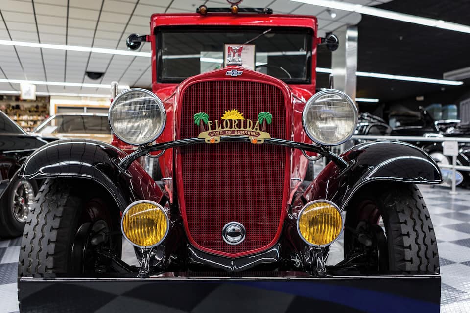 A vintage red car with a prominent front grille and headlights.