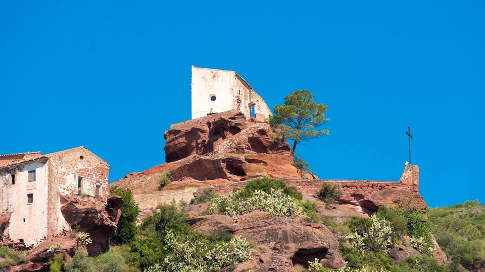 A historic building perched on a rocky hill with a clear blue sky.