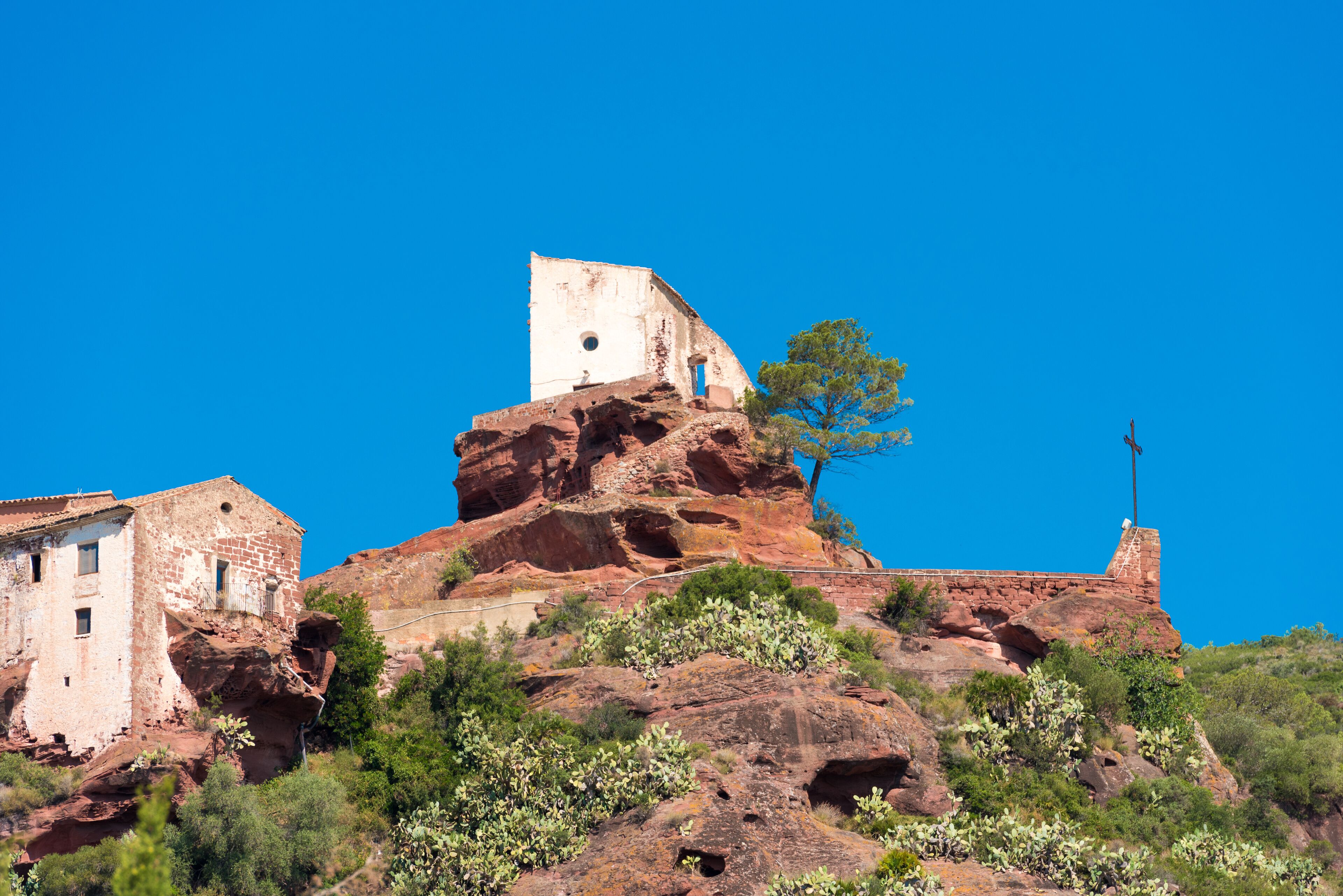 A historic building perched on a rocky hill with a clear blue sky.