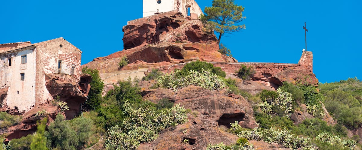 A historic building perched on a rocky hill with a clear blue sky.