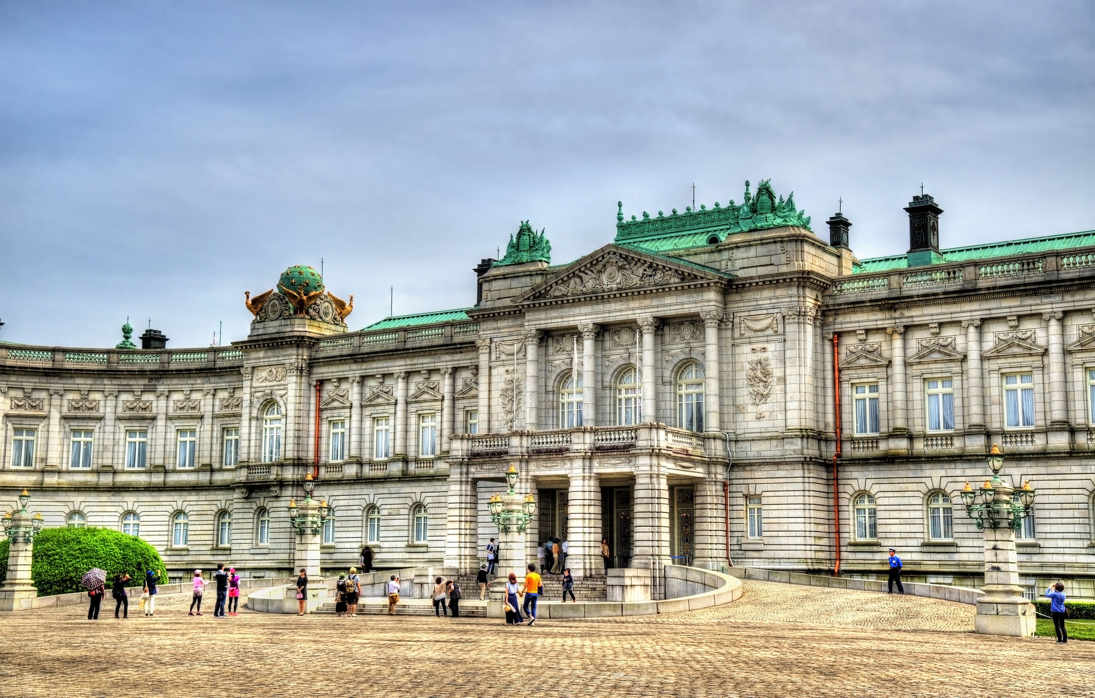 Um edifício histórico imponente com arquitetura elaborada, uma cúpula central e um amplo pátio.