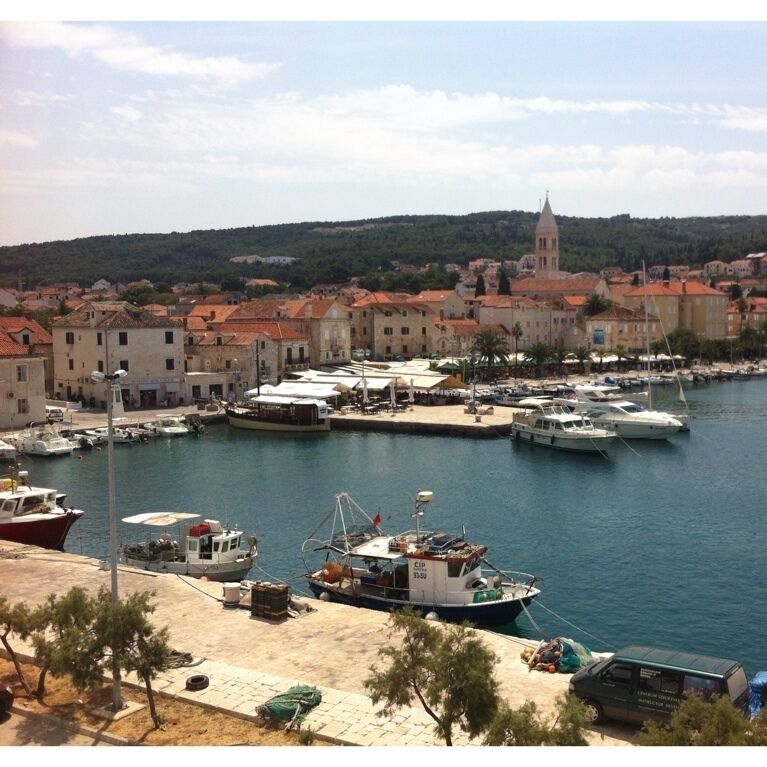 A harbor with boats, a church, and buildings along the waterfront.