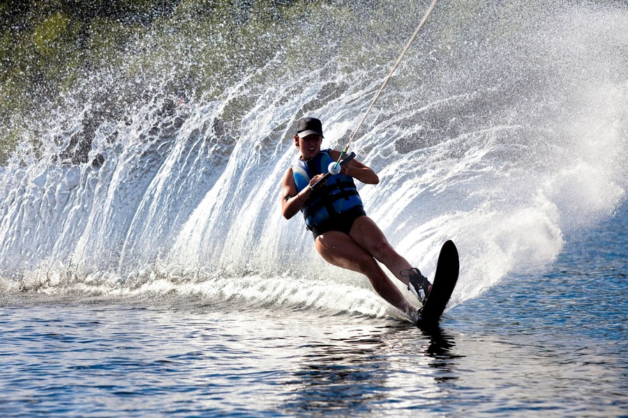 A female water skier rips a turn causing a huge water spray while skiing on Cobbosseecontee Lake near Monmouth, Maine.