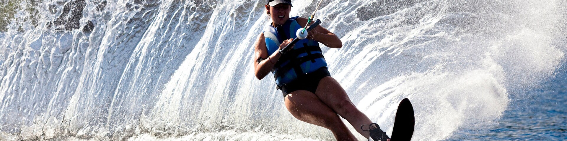 A female water skier rips a turn causing a huge water spray while skiing on Cobbosseecontee Lake near Monmouth, Maine.