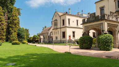 A historic building with a well-manicured lawn and an ornate entrance.