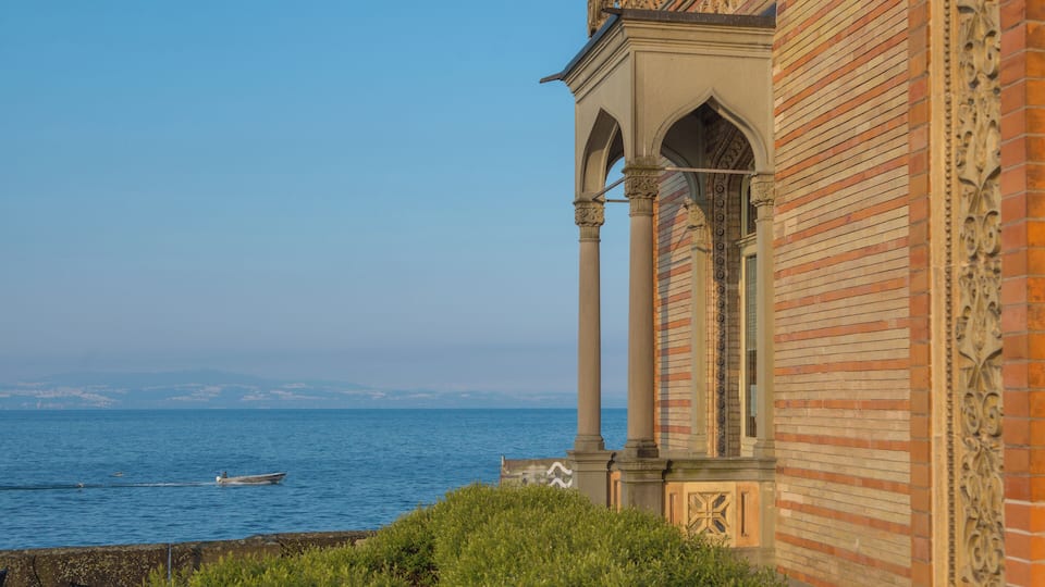 A coastal building with columns and intricate brickwork, overlooking the sea.