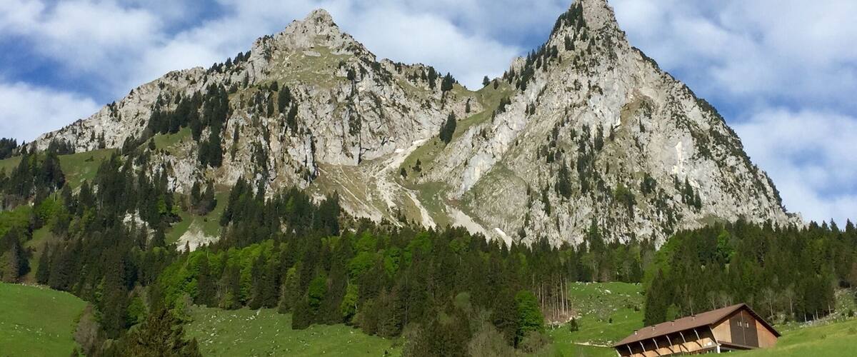 A mountain with a small cabin in the foreground.