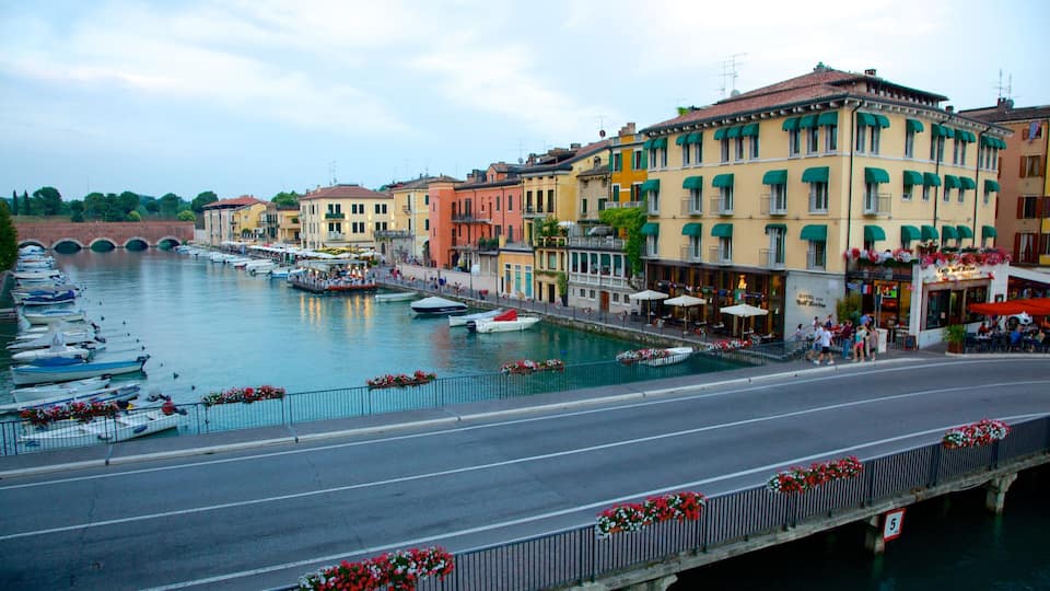 A canal with boats, a bridge, and colorful buildings along the water.