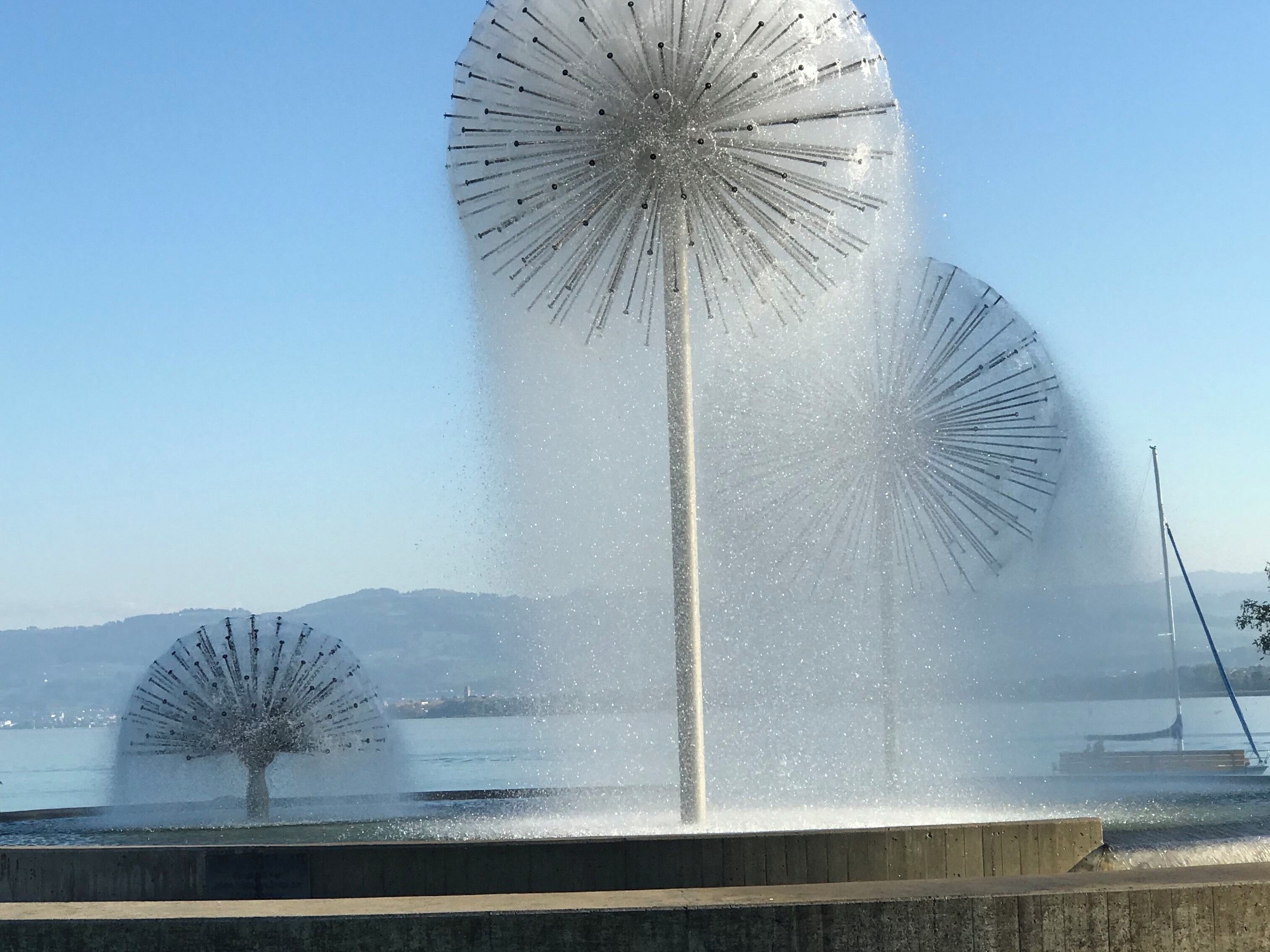 A fountain with multiple water jets and a clear sky.