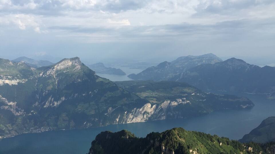 A mountainous landscape with a lake and distant mountains.