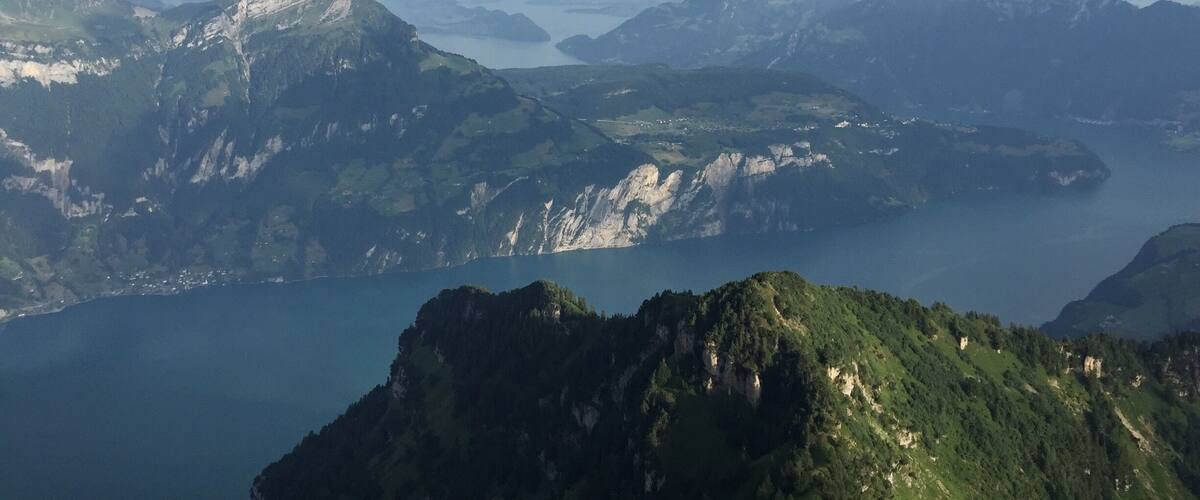 A mountainous landscape with a lake and distant mountains.