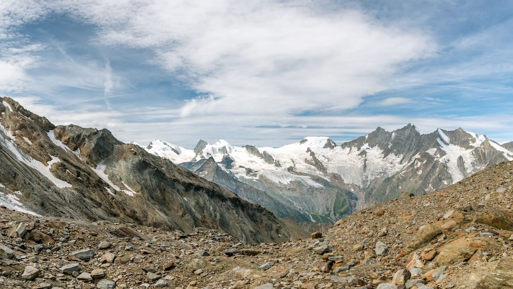 Eine zerklüftete Berglandschaft mit schneebedeckten Gipfeln und felsigem Gelände.