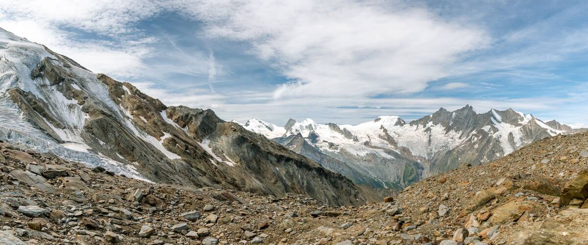 A rugged mountain landscape with snow-capped peaks and rocky terrain.
