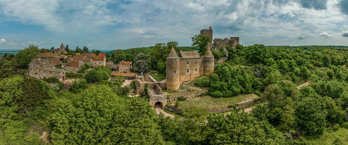 A historic castle surrounded by lush greenery and rolling hills.