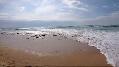 A sandy beach with gentle waves and a clear sky.