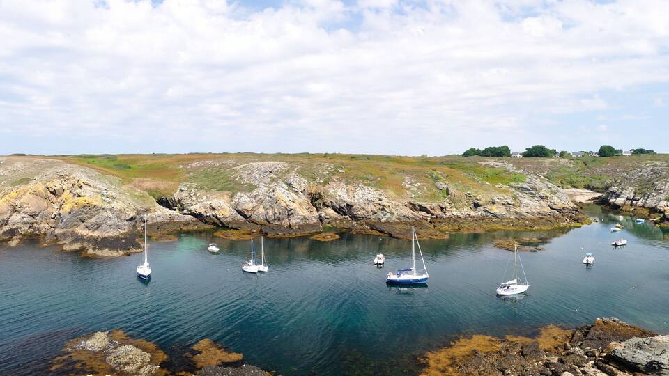 A coastal landscape with rocky shores and clear blue water.