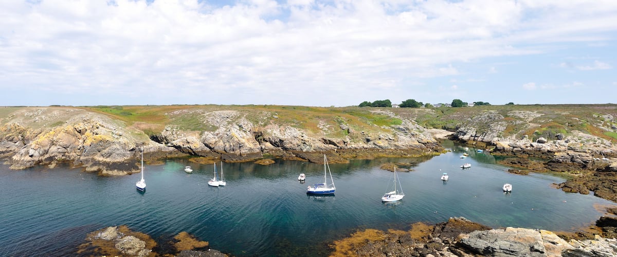 A coastal landscape with rocky shores and clear blue water.