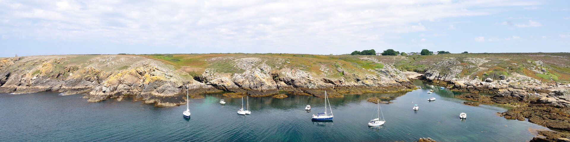 A coastal landscape with rocky shores and clear blue water.
