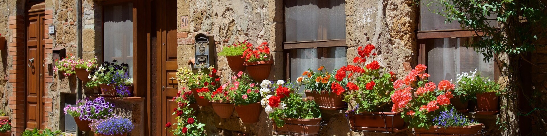 Un edificio rústico con numerosas macetas llenas de flores coloridas.