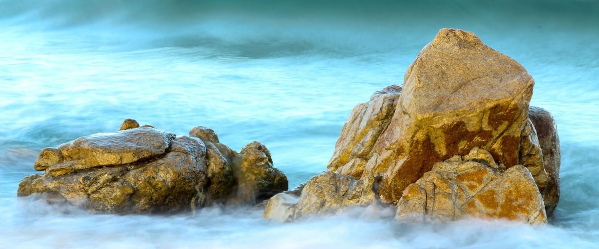 A rocky shoreline with waves crashing against the rocks.
