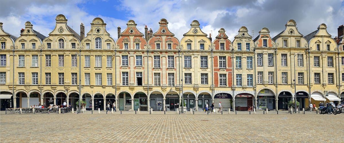 A historic building with ornate architecture and a cobblestone plaza.