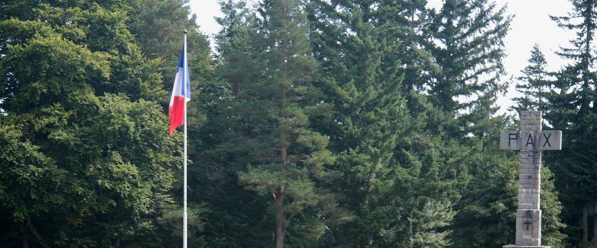 A cemetery with numerous gravestones, a flagpole with a flag, and a monument labeled "PAX".