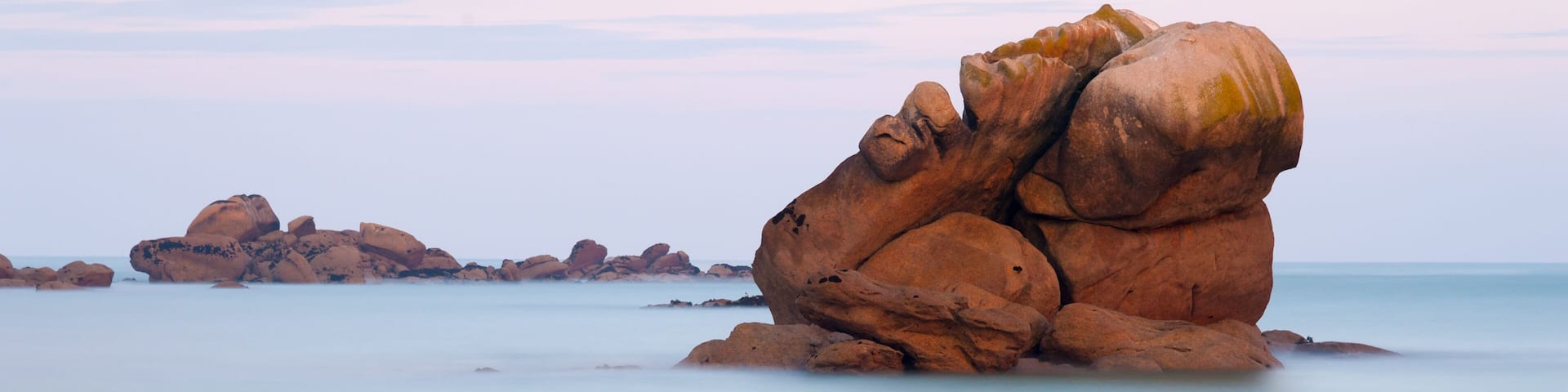Felsen auf spiegelglattem Meer bei Meneham, Côte des Légendes, Bretagne, Frankreich