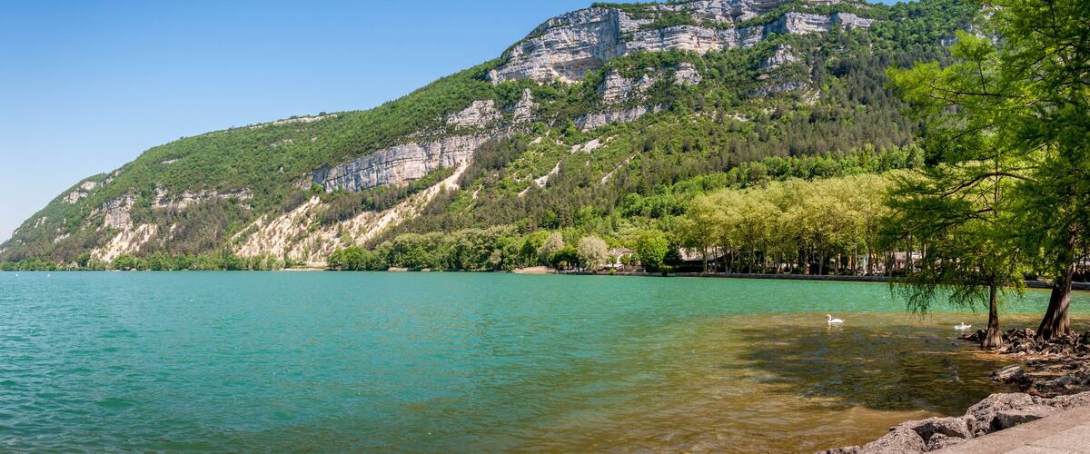 A calm lake surrounded by forested hills.